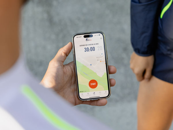 Sudionik utrke provjerava svoj telefon, čekajući početak utrke.